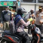 Kapolres Mojokerto Kota bagi-bagi masker kepada para pengguna jalan bersama tiga pilar serta ditemani boneka Polisi Lantas Bermasker.