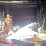 Petugas Damkar saat berjibaku menjinakkan api di toko mebel Sumber Rezeki, Jl. Kertajaya, Surabaya. 