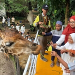 Puluhan anak yatim saat diajak feeding jerapah dalam kegiatan ngabuburit di KBS bersama Wartawan Pokja Grahadi.