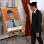 Presiden RI Joko Widodo melihat foto K.H. Masjkur dalam acara penganugerahan gelar pahlawan nasional, Jumat (8/11/2019). foto: istimewa/ bangsaonline.com