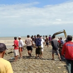 Aktivitas ekskavator ketika mengeruk terumbu karang di area menuju muara nelayan di Pasean, Pamekasan, Madura. 