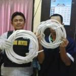 Tersangka (kanan) didampingi petugas saat menunjukkan barang bukti berupa gulungan kabel. foto: rusmiyanto/BANGSAONLINE