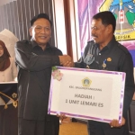 Bupati Gresik Sambari Halim Radianto memberikan hadiah kepada Camat Balongpanggang karena paling banyak desanya lunas PBB selama Periode Agustus-Desember 2016. foto: SYUHUD/ BANGSAONLINE