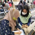 Petugas dari BPJS Kesehatan saat memberi pelayanan ke pasien.