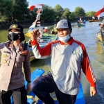 Kapolsek Sedati AKP Agnis J Manurung bersama seorang nelayan di atas perahu.