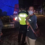 Petugas dari Polsek Ngadiluwih dibantu warga saat akan mengevakuasi korban laka atas nama Fuji Slamet. Foto: Ist.