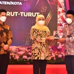 Bupati Gresik Fandi Akhmad Yani menerima penghargaan dari Gubernur Jatim Khofifah Indar Parawansa. foto: SYUHUD/ BANGSAONLINE