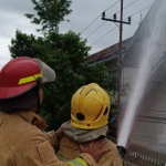 Petugas Damkar saat berusaha memadamkan api. (Ist). 