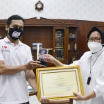Yudi Arianto, Wartawan HARIAN BANGSA saat menerima piagam penghargaan dan trofi dari Wali Kota Surabaya Tri Rismaharini. (foto: ist.)