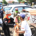 Gubernur Jawa Timur Khofifah Indar Parawansa saat membagikan sembako pada para tukang becak di Jember,  Minggu (15/11/2020). foto: ist/ bangsaonline.com  