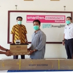 Sirojuddin, Leader Smartfren Community Natuna, menyerahkan bantuan secara simbolis kepada perwakilan sekolah di Natuna.