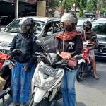 Dua ibu-ibu turun dari sepeda motornya untuk bersama-sama mengheningkan cipta di Simpang 3 Jalan Soekarno Hatta, Katang. foto: MUJI HARJITA/ BANGSAONLINE