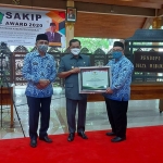 PENGHARGAAN: Pj. Bupati Hudiyono menyerahkan SAKIP Awards kepada Kadis Perikanan Sidoarjo M. Bachruni Aryawan, Senin (30/11/2020). (foto: ist)