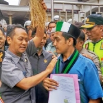 Ketua DPRD Kota Blitar Syahrul Alim menerima sapu lidi pemberian mahasiswa.