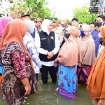 Gubernur Jawa Timur terpilih, Khofifah Indar Parawansa, saat berbincang dengan warga terdampak banjir.