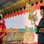 Ketua DPC PDIP Kabupaten Kediri, Murdi Hantoro, saat memegang tokoh wayang sebelum diserahkan ke Ki Didik Wibisono. Foto: MUJI HARJITA/BANGSAONLINE
