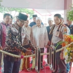 Bupati Bangkalan R. Abdul Latif Imron Amin saat meresemikan Mapolsek Burneh ditandai dengan pengguntingan rangkaian bunga.