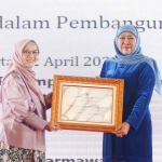 Khofifah Indar Parawansa saat menerima penghargaan dari Menteri Pemberdayaan Perempuan dan Perlindungan Anak.