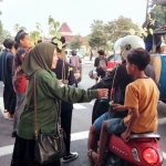 Para peserta kegiatan Eco Ramadhan 2025 saat membagikan bibit pohon kepada pengendara di utara Alun-Alun Tuban