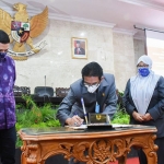 Wali Kota Kediri, Abdullah Abu Bakar (batik ungu) menyaksikan penandatanganan Raperda oleh Ketua DPRD Kota Kediri, Agus Sunoto. (foto: Ist).