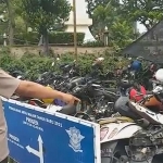 Petugas saat menunjukkan motor yang ringsek akibat diseruduk truk boks di Pandaan, Kabupaten Pasuruan.