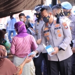 Kapolres Madiun AKBP Anton Prasetyo saat membagikan masker kapada pedagang maupun pembeli di Pasar Pagotan.