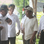 Wabup Kang Marhaen saat berbicara dengan Tukinah yang sebagian rumahnya ikut dibongkar. foto: BAMBANG/ BANGSAONLINE