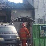 Petugas pemadam kebakaran saat melakukan pembasahan di gudang cat Sidoarjo.
