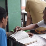 Salah satu warga binaan Lapas Kediri saat belajar membaca Alquran. Foto: Ist