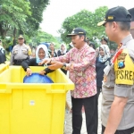 Wabup Moh. Qosim dan Kapolres AKBP Wahyu S. Bintoro saat membuang sampah. foto: SYUHUD/ BANGSAONLINE