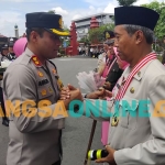 Kapolres Madiun Kota mengkalungkan tanda mata dan beri salam perpisahan. Foto: Hendro Suhartono/BANGSAONLINE