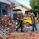 Anggota Kodim 0817 saat membantu membersihkan atap SMPN 2 Kebomas yang ambrol.