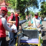 Bupati Ngawi Ir. Budi Sulistyono sedang membagikan paket sembako ke para tukang becak.