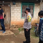 Petugas kepolisian saat mendatangi lokasi penyabetan yang dilakukan Hartono kepada pamannya di Dusun Becok, Desa Tegalrejo, Kecamatan Merakurak, Kabupaten Tuban.