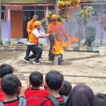 Tim BPBD Jatim bersama Pak Guru Ribut saat memberikan edukasi penanganan munculnya kobaran api