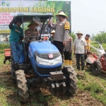 Karo SDM Polda Jatim bersama Kapolres Kediri saat menaiki traktor di ladang jagung. Foto: Ist