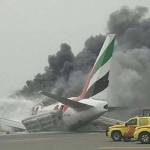 Petugas saat berusaha memadamkan api pesawat Emirates Airline. Pesawat tujuan Thiruvananthapuram, India-Dubai itu menghantam keras landasan saat mendarat hingga menyebabkan kebakaran. 