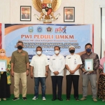 Ketua PWI Jatim, Lutfil Hakim, dan Sekda Lamongan, Moh Nalikan, usai menyerahkan sertifikat P-IRT untuk UMKM di Aula Lesung Sipanji Dinas Kesehatan Lamongan.