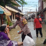 
Anggota Polres Gresik memberikan bantuan kepada korban banjir. foto: SYUHUD/BANGSAONLINE.com