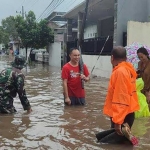 Petugas BPBD dan personel TNI saat meninjau banjir di Jalan Kaliurang Kecamatan Sumbersari Jember, Minggu (19/1/2025).