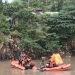 Personel gabungan dari Basarnas, Tim SAR dan BPBD Kota Surabaya saat mengevakuasi korban di Sungai Jagir, Wonokromo, Surabaya, Jumat (31/1/2025).