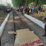 Korban tertabrak kereta api di Maspion IIII Gedangan, ditutupi kardus oleh warga sekitar sebelum dilakukan evakuasi.