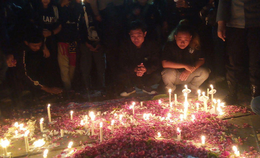 Doa bersama di Stadion Wilis Madiun diwarnai tabur bunga dan nyala lilin. Foto: HENDRO SUHARTONO/ BANGSAONLINE