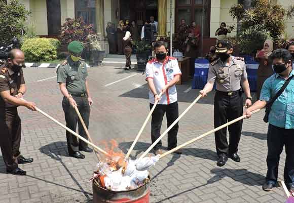 Kepala Kejaksaan Negeri Hendrizal Husain, SH, Kapolres Malang Kota AKBP Singgamata, Dandim 0833 Kota Malang Letkol Arya Yudha S, serta perwakilan dari PN Malang saat mengawali pembakaran barang bukti. (foto: iwan irawan/BANGSAONLINE)