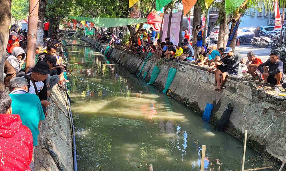 Para peserta lomba pancing sedang asyik menunggu ikan menyambar umpannya, Ahad (18/8/2924). Foto: M MASUD ADNAN/ BANGSAONLINE