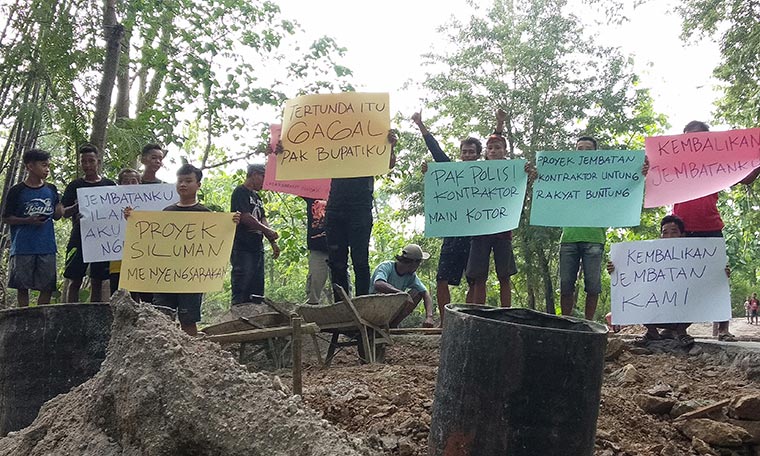 Warga Desa Bulak, Kecamatan Balong Ponorogo yang demo membentangkan poster yang bunyinya macam-macam, Sabtu (14/11/2020). foto: novian catur/ bangsaonline.com