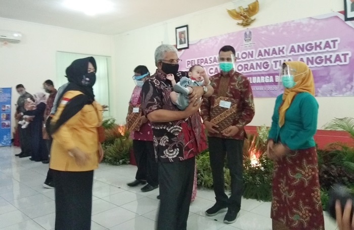 Kadinsos M Alwi (baju batik) saat menyerahkan bayi ke salah satu orangtua asuh.