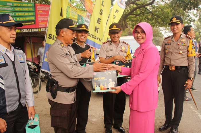 Ketua Bhayangkari Ny Sistri Wahyu S Bintoro saat memberikan bingkisan kepada petugas pos pam lebaran. 