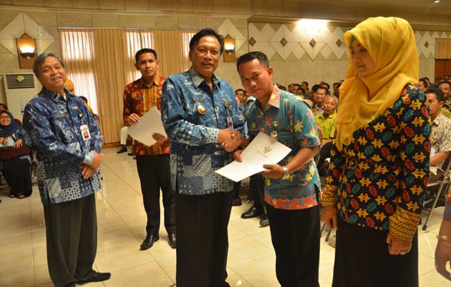 Bupati Gresik Sambari HR didampingi Plt Sekkab, Bambang Isdianto saat penyerahan SK PNS. foto: syuhud/ BANGSAONLINE