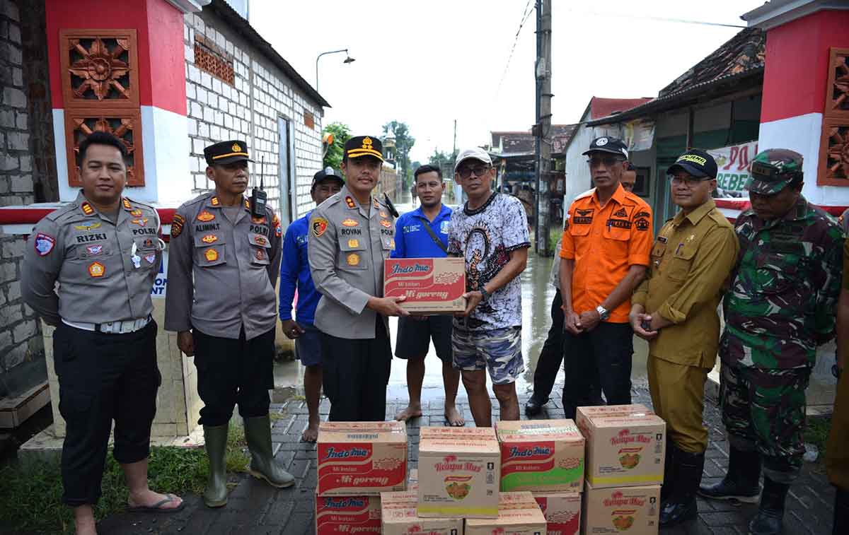Kapolres Gresik saat menyerahkan bantuan kepada Kades Balurejo untuk korban terdampak banjir. Foto: Ist